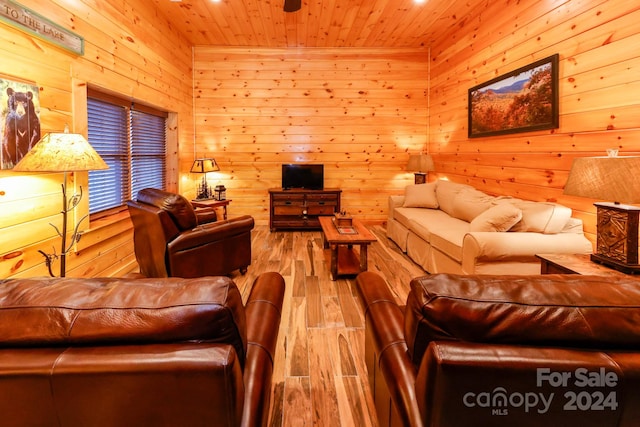 living room with wooden ceiling, light wood-type flooring, and wooden walls