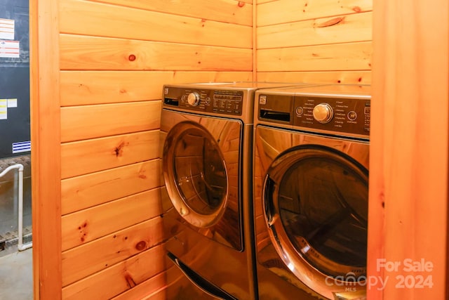 laundry area featuring independent washer and dryer and wooden walls