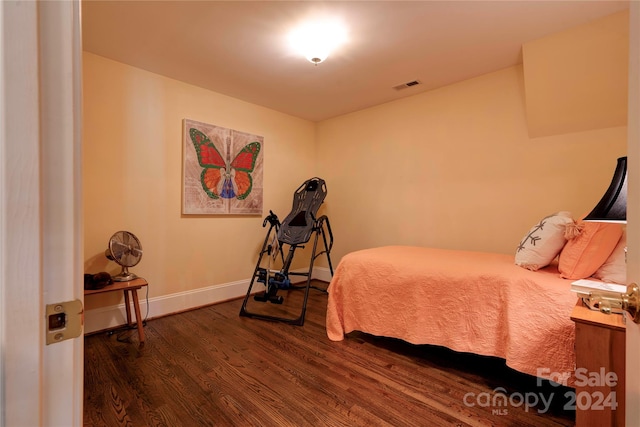 bedroom with dark hardwood / wood-style flooring