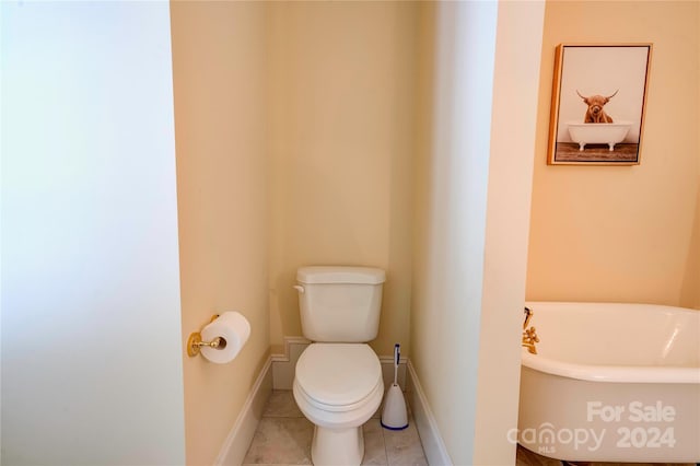 bathroom featuring tile patterned flooring, toilet, and a bathing tub