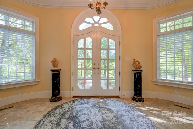 entryway featuring french doors, light tile patterned floors, and ornamental molding