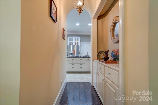 corridor with light hardwood / wood-style flooring and ornamental molding