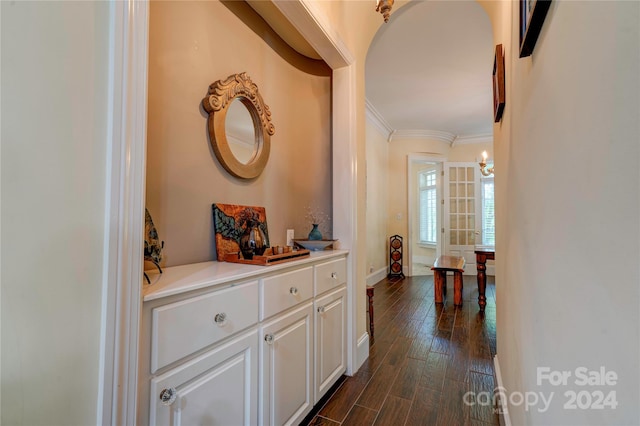 hallway with dark hardwood / wood-style floors and crown molding