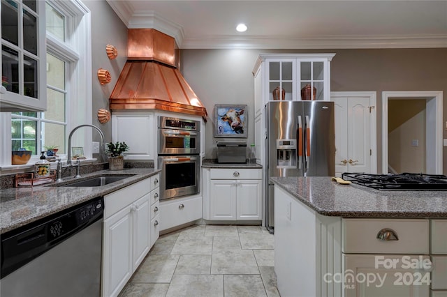 kitchen featuring appliances with stainless steel finishes, white cabinetry, dark stone countertops, and sink