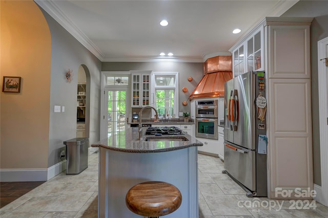 kitchen with white cabinets, crown molding, stainless steel appliances, and dark stone counters