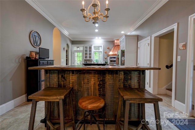 bar with a chandelier, stainless steel fridge, light tile patterned floors, and ornamental molding