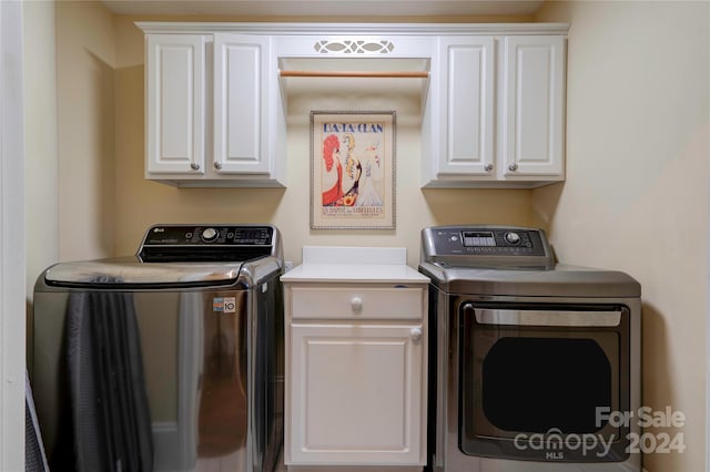 washroom featuring cabinets and separate washer and dryer