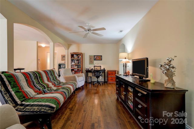 living room with dark hardwood / wood-style flooring and ceiling fan