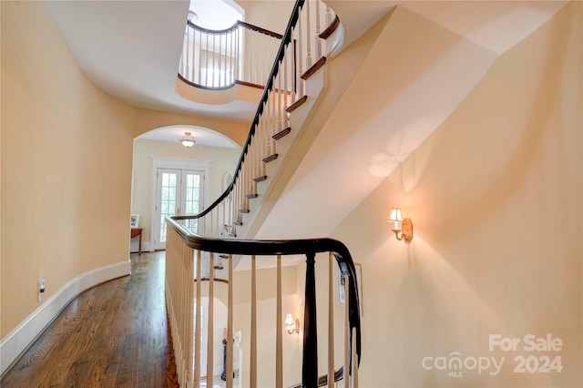 stairway with hardwood / wood-style floors and french doors