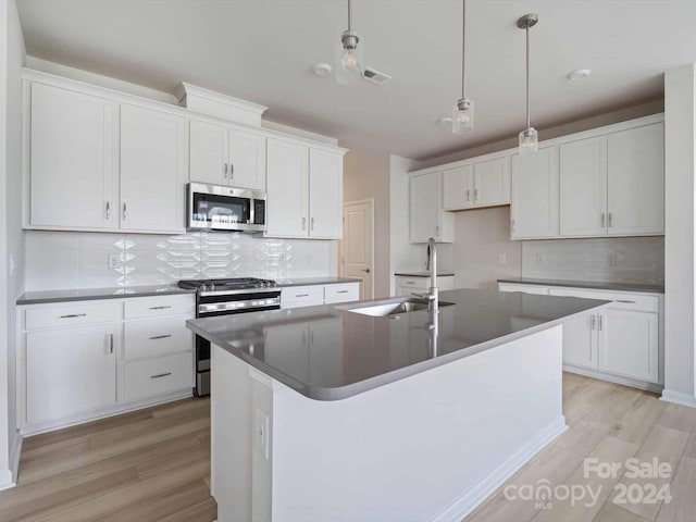 kitchen featuring white cabinets, stainless steel appliances, and backsplash