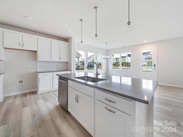 kitchen featuring a kitchen island with sink, white cabinetry, and sink