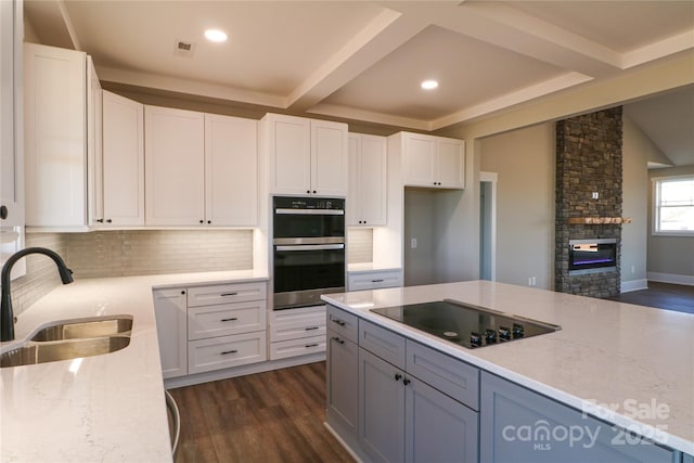 kitchen with white cabinetry, double wall oven, sink, and black electric stovetop