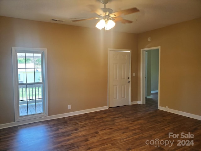 empty room featuring dark hardwood / wood-style flooring and ceiling fan