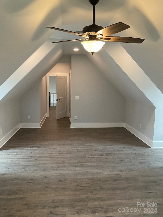 additional living space featuring dark wood-type flooring, ceiling fan, and lofted ceiling