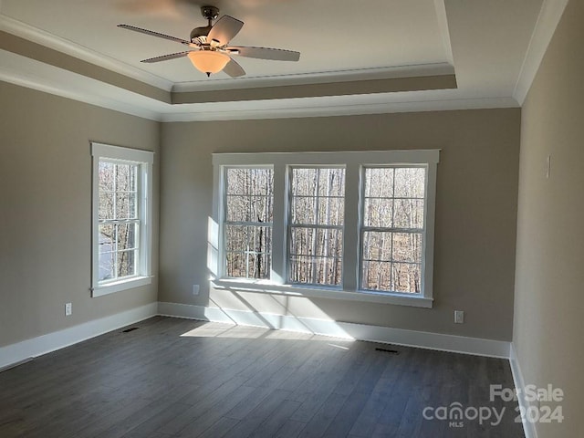 unfurnished room featuring dark hardwood / wood-style flooring, a raised ceiling, ceiling fan, and crown molding