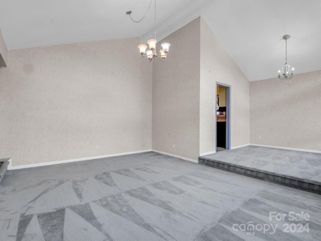 empty room with lofted ceiling, dark colored carpet, and a notable chandelier