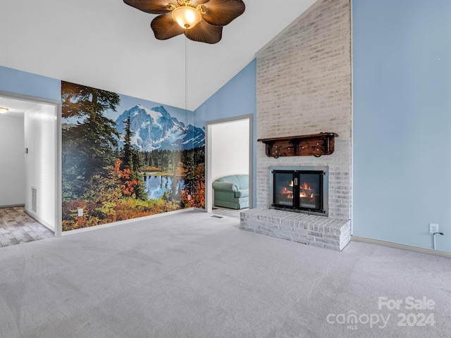 unfurnished living room with high vaulted ceiling, ceiling fan, a fireplace, and light carpet