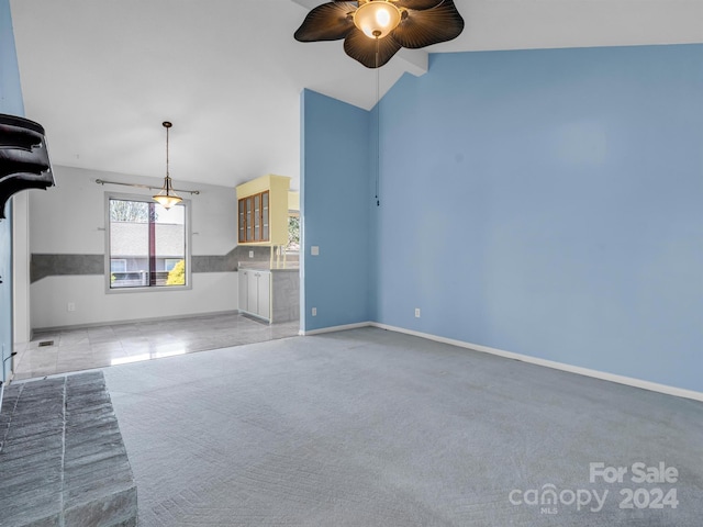 unfurnished living room featuring ceiling fan, vaulted ceiling, and light carpet