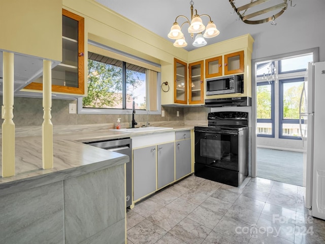 kitchen with hanging light fixtures, light tile flooring, backsplash, appliances with stainless steel finishes, and sink