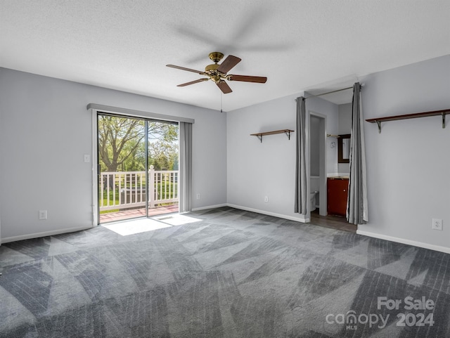 empty room with ceiling fan, dark carpet, and a textured ceiling