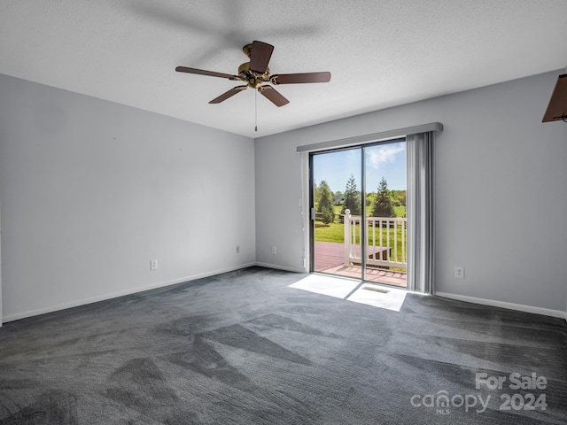 carpeted empty room featuring ceiling fan and a textured ceiling