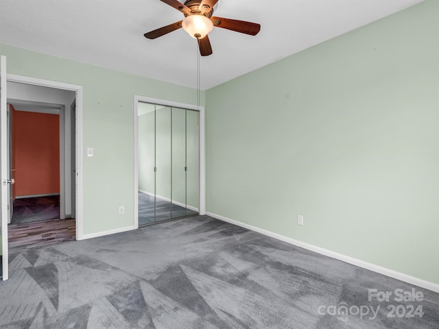 unfurnished bedroom with a closet, ceiling fan, and dark carpet