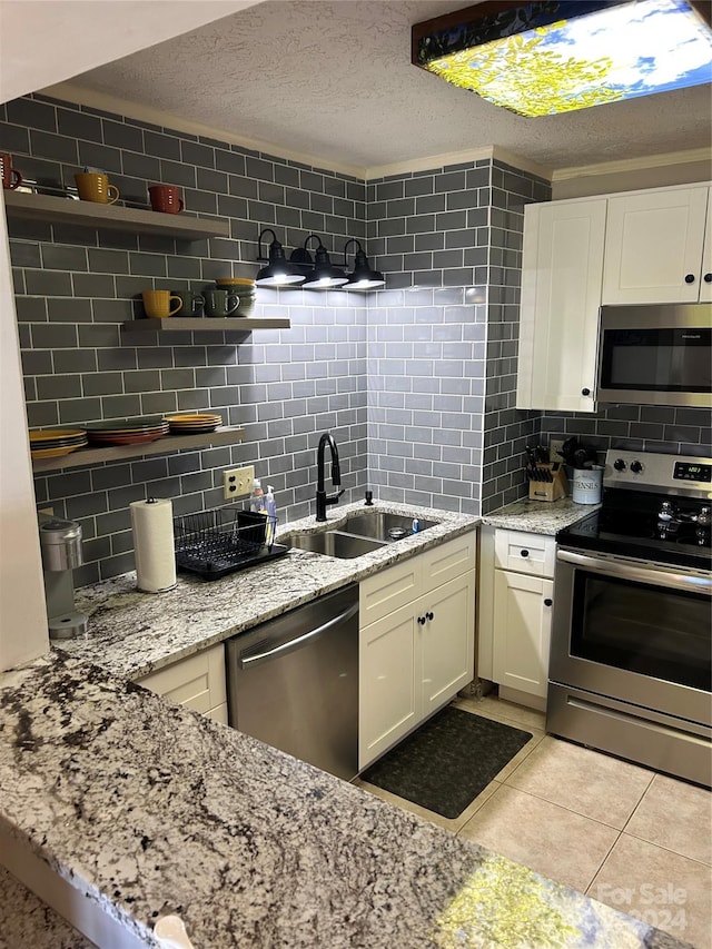 kitchen featuring backsplash, sink, stainless steel appliances, and light stone counters