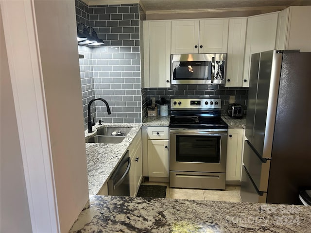 kitchen featuring sink, appliances with stainless steel finishes, tasteful backsplash, and light stone counters