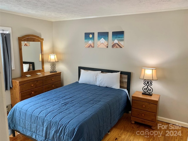 bedroom with ornamental molding, dark hardwood / wood-style floors, and a textured ceiling