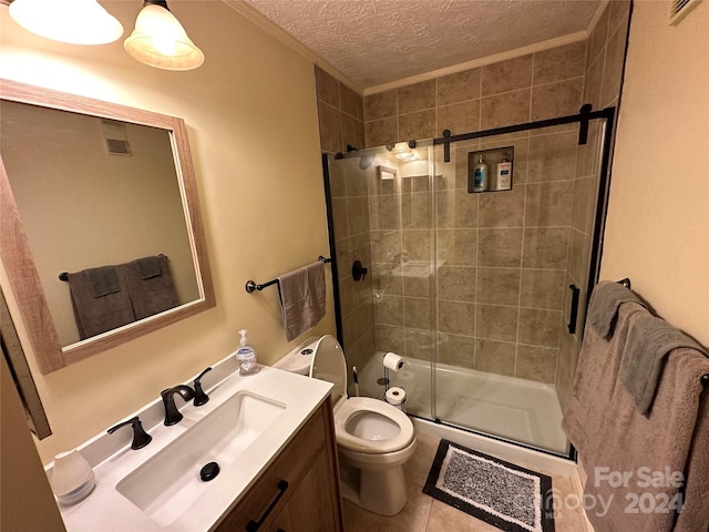 bathroom featuring a shower with door, vanity, tile flooring, toilet, and a textured ceiling