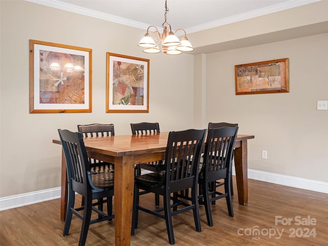 dining space with dark hardwood / wood-style flooring, crown molding, and a notable chandelier