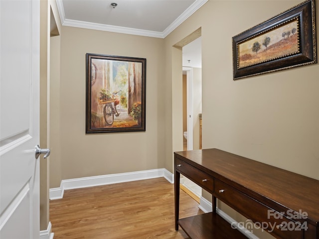 hallway featuring crown molding and light hardwood / wood-style floors