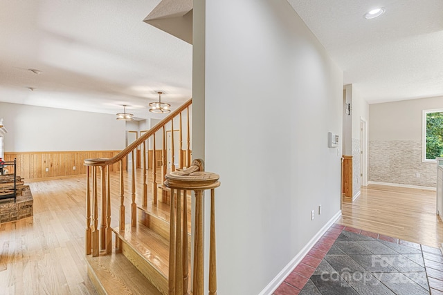 stairs with hardwood / wood-style flooring and a notable chandelier