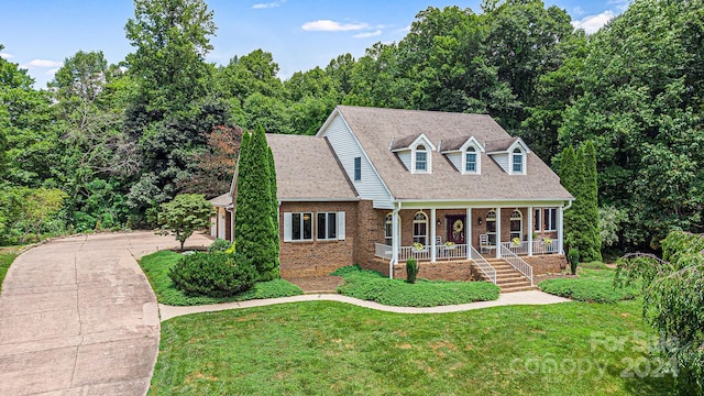 cape cod home featuring covered porch and a front yard