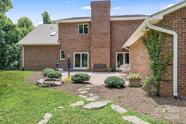 rear view of property with a yard, a patio area, and french doors