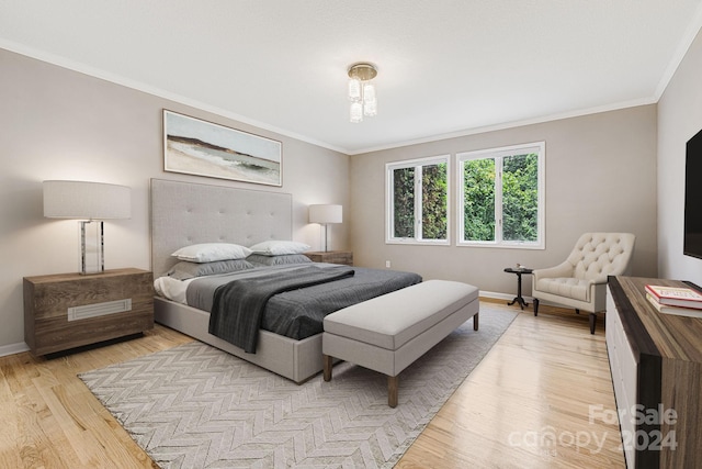 bedroom with light hardwood / wood-style floors and crown molding