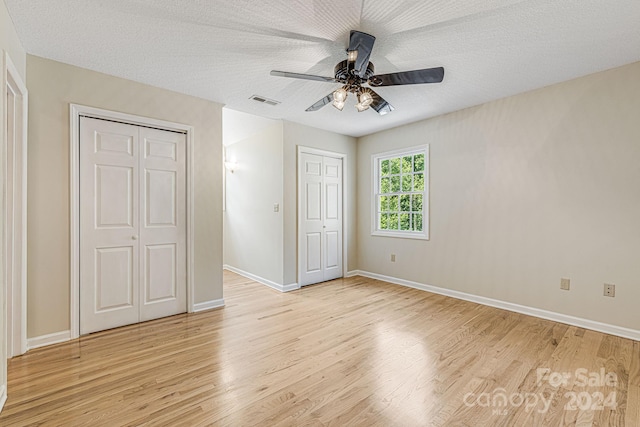 unfurnished bedroom featuring a textured ceiling, light hardwood / wood-style flooring, and ceiling fan