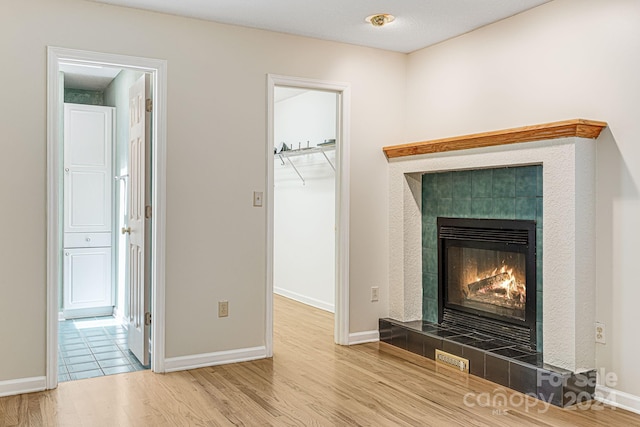 interior space with wood-type flooring and a tiled fireplace