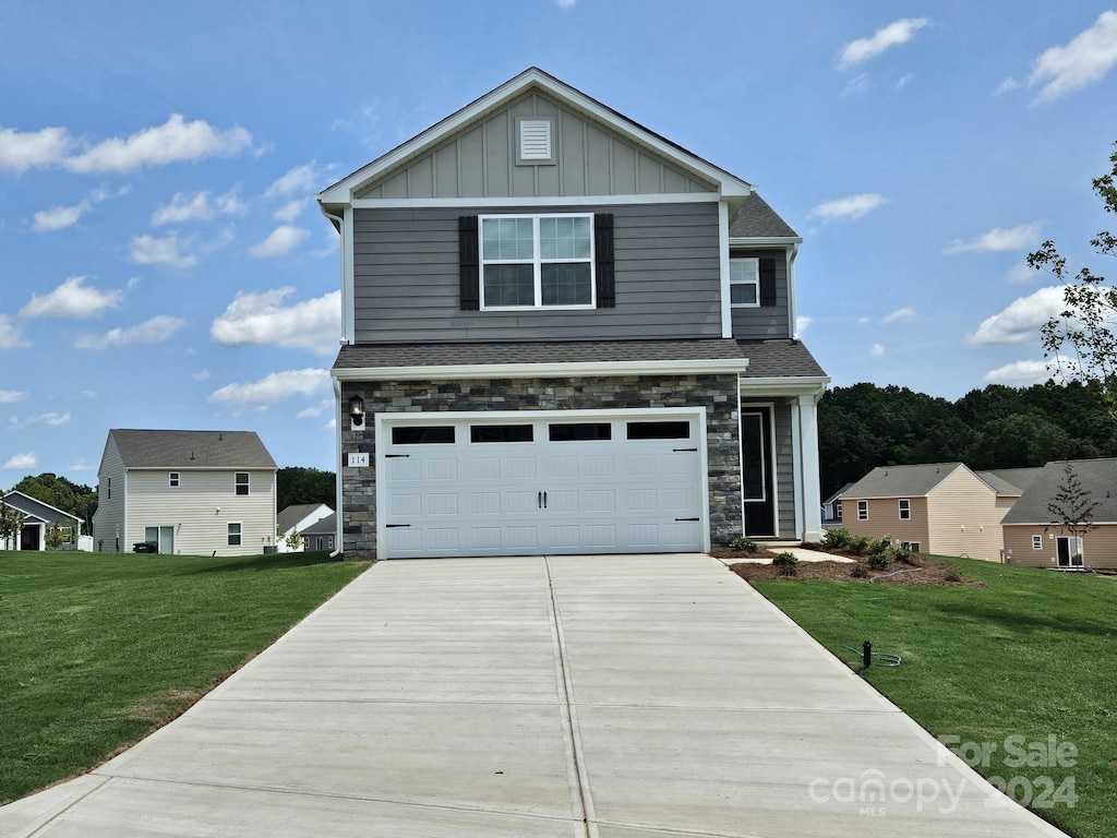 view of front of property featuring a front yard and a garage