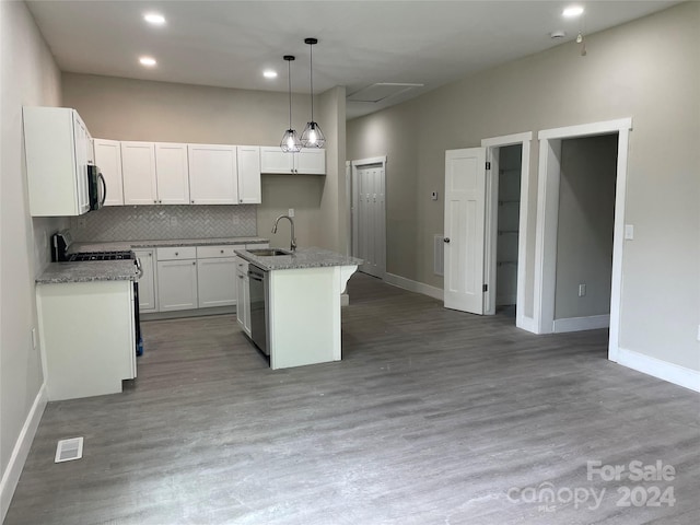 kitchen featuring white cabinetry, hardwood / wood-style flooring, and a kitchen island with sink