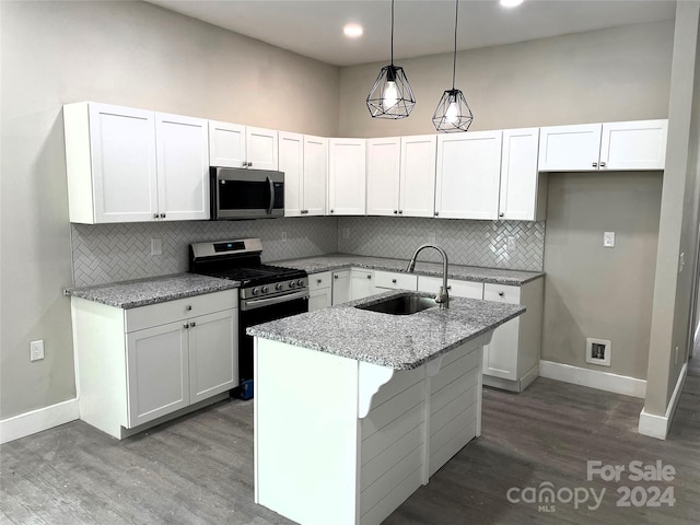 kitchen with hardwood / wood-style flooring, stainless steel appliances, and white cabinetry