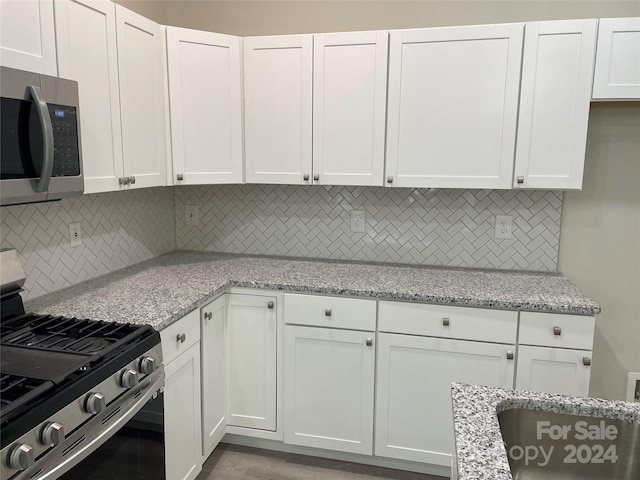 kitchen featuring appliances with stainless steel finishes, tasteful backsplash, and white cabinets