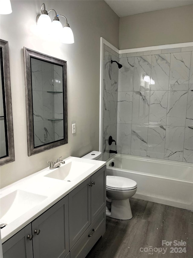 full bathroom with wood-type flooring, toilet, tiled shower / bath, and dual vanity