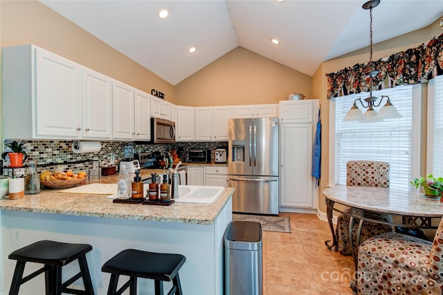 kitchen featuring white cabinetry, stainless steel appliances, kitchen peninsula, decorative backsplash, and light tile patterned flooring