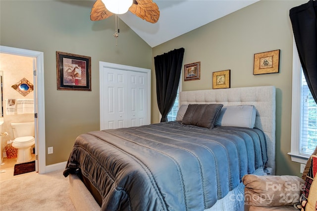 carpeted bedroom with ceiling fan, lofted ceiling, ensuite bathroom, and a closet