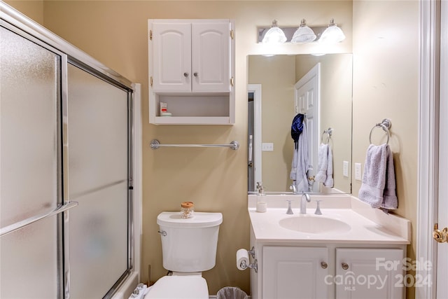 bathroom with toilet, vanity, and walk in shower