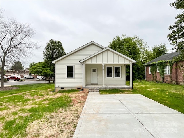 bungalow-style house with a front lawn and covered porch