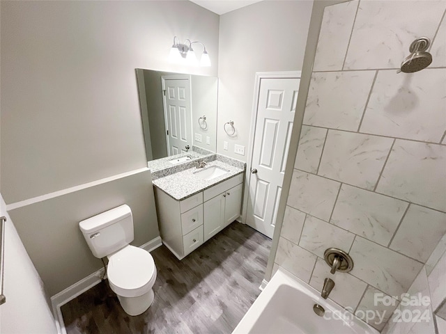 full bathroom with shower / washtub combination, toilet, vanity, and hardwood / wood-style floors