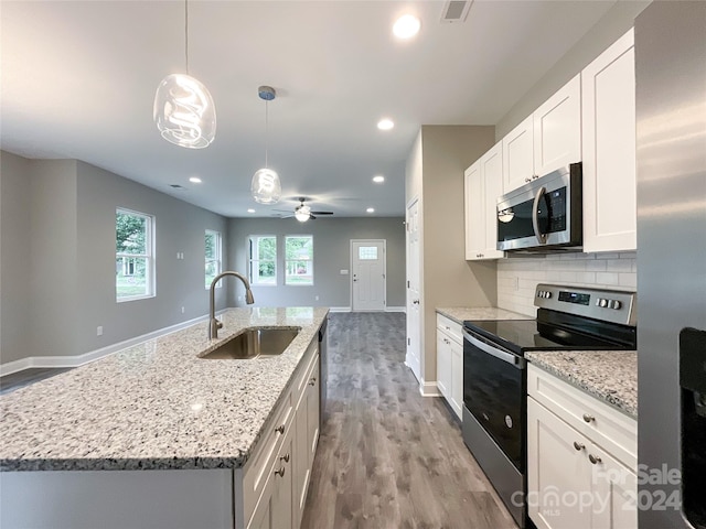 kitchen with backsplash, ceiling fan, stainless steel appliances, sink, and light wood-type flooring