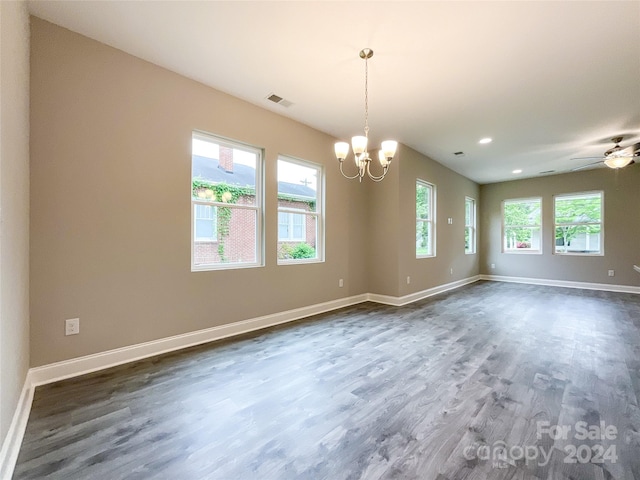 spare room featuring ceiling fan with notable chandelier and dark hardwood / wood-style flooring